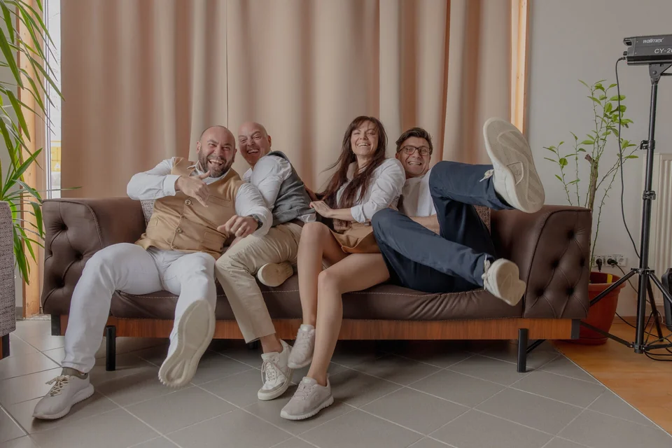 Hochzeitsfotograf René Cerny mit seinem Team auf dem Sofa, von links René, Daniel, Eugenia und Denny, lockerer Moment hinter den Kulissen einer Hochzeitsreportage
