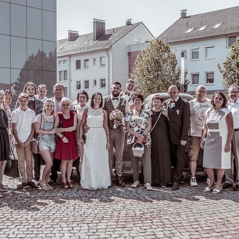Brautpaar mit Familie und Hochzeitsgästen beim Gruppenfoto nach der standesamtlichen Trauung