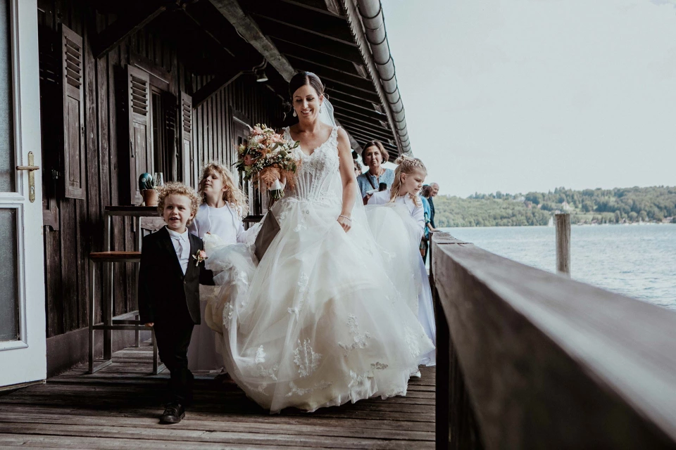 Braut mit kindern und blumenstrauss am steg hochzeitsreportage hochzeitsfotograf rene cerny starnberger see