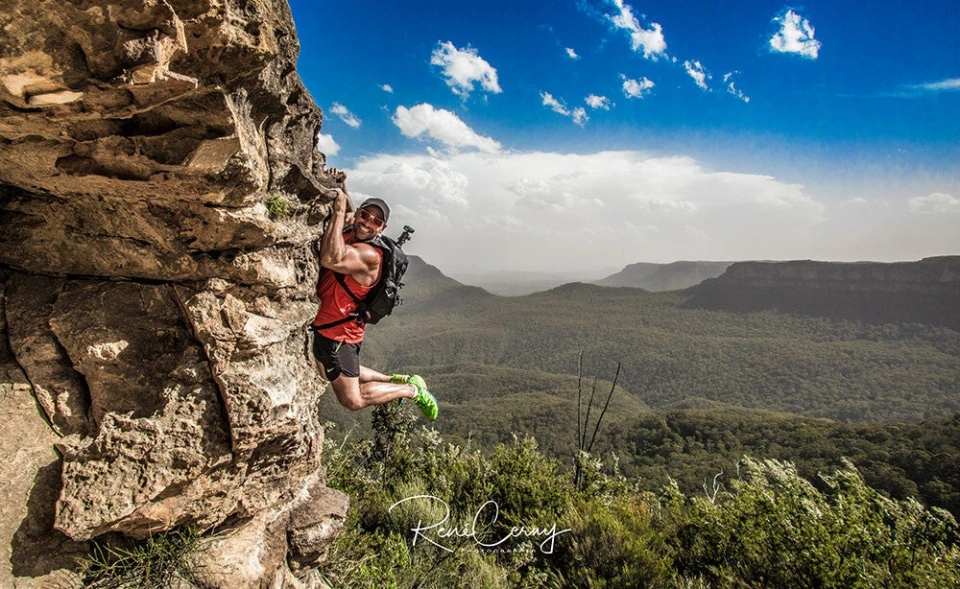 Fotograf René Cerny – Reisefotografie. René klettert an einer Felswand mit Blick über die Blue Mountains, Australien.
