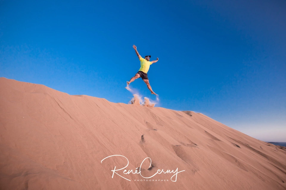 Fotograf René Cerny – Reisefotografie. René springt von einer Sanddüne, Australien.