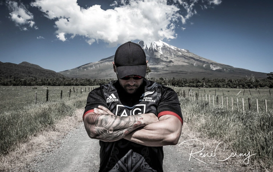 Fotograf René Cerny – Reisefotografie. René im Maori-All-Blacks-Trikot vor dem Vulkan Taranaki, Neuseeland.