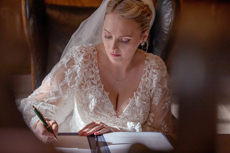 Braut bei Unterzeichnen der Dokumente, Hochzeitfofotos Galerie